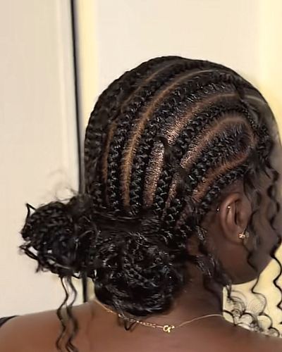 Stitch feed-in cornrows gathered into a curly low bun